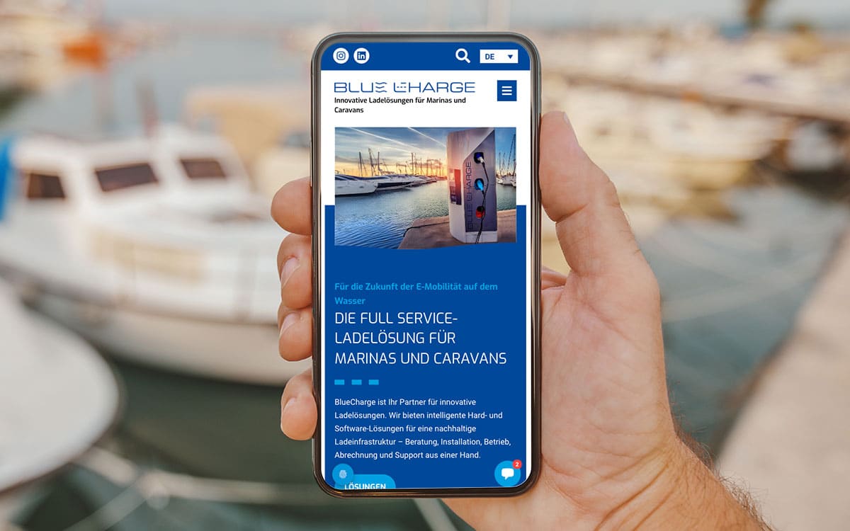 Hand hält Smartphone mit Webseite für Ladestationen.