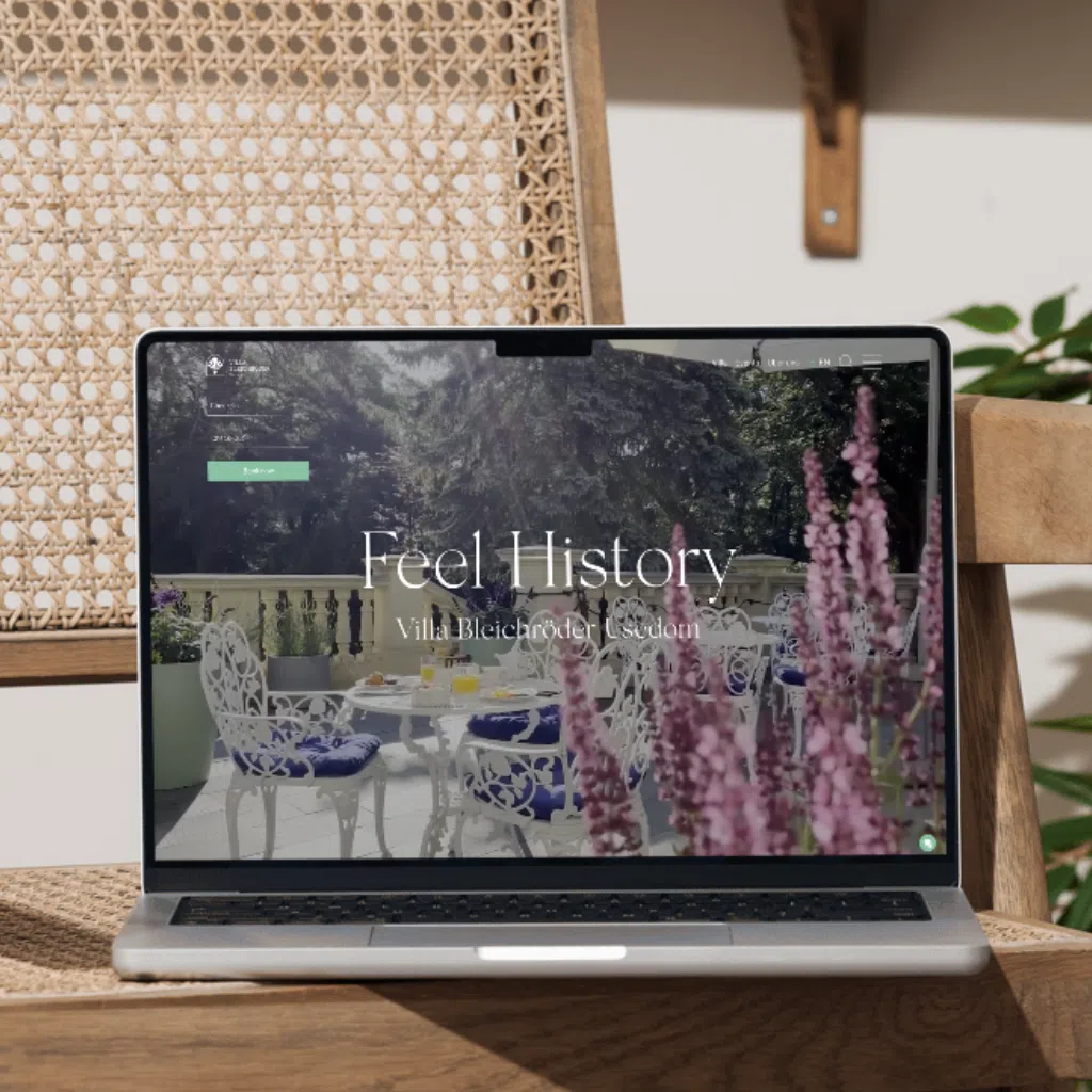 Laptop auf Holzstuhl mit Hotelwebsite auf Bildschirm
