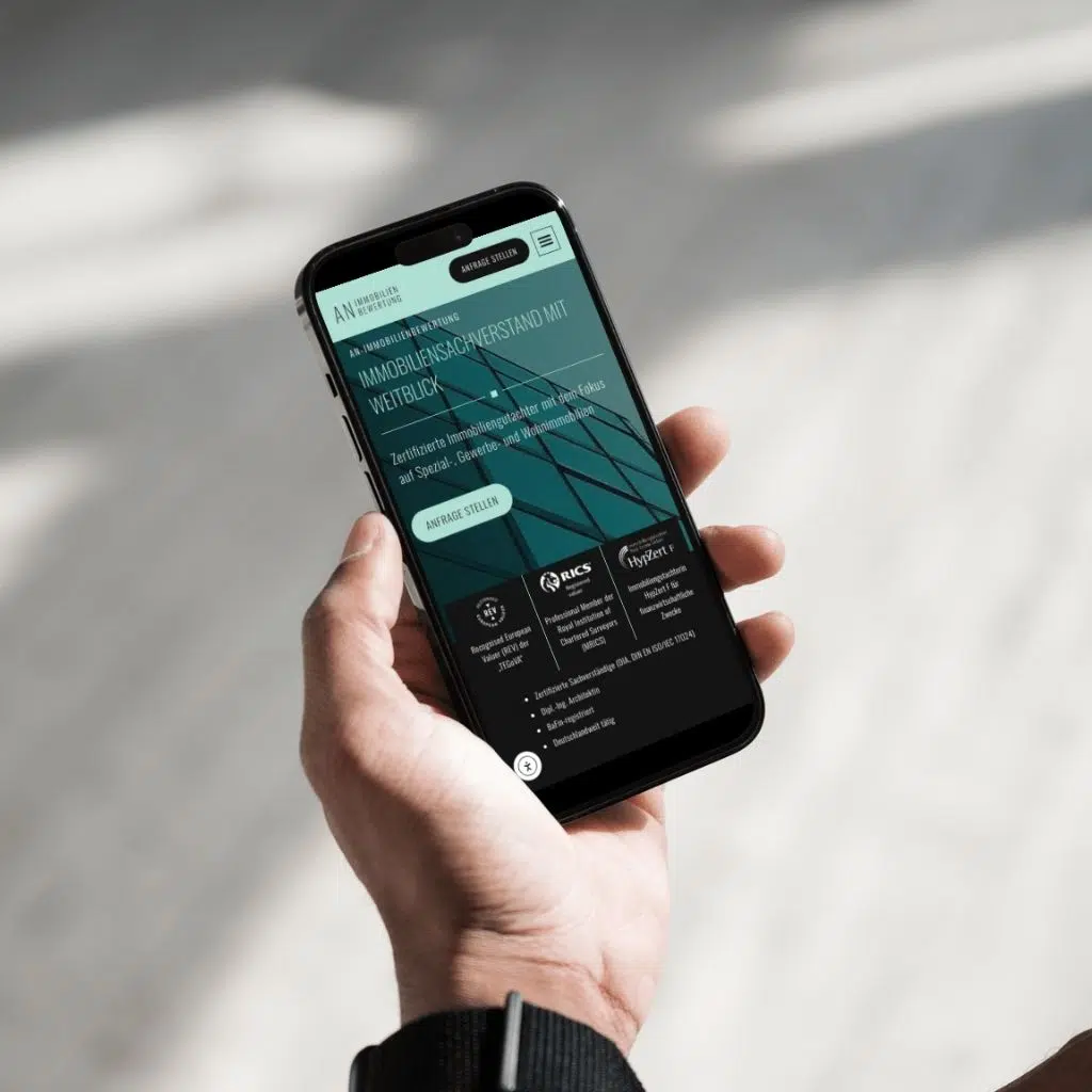 Smartphone mit Immobilienbewertungs-Website in Hand